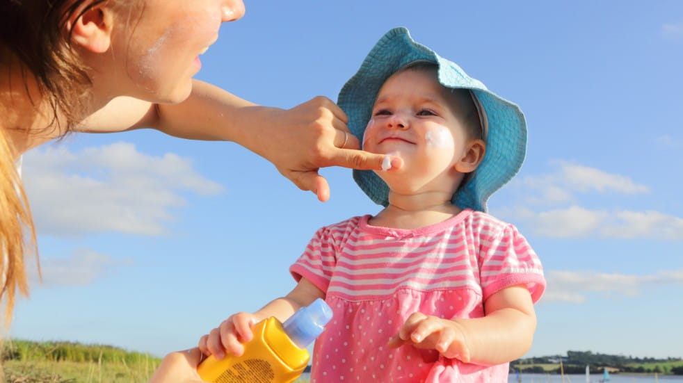 parent putting suncream on child